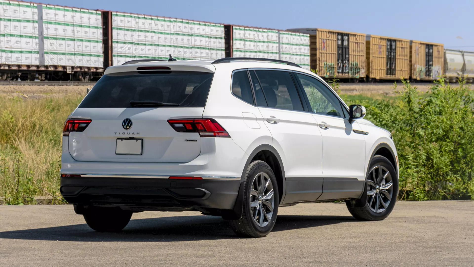rear side view of a 2024 VW Tiguan on a road with a passing train