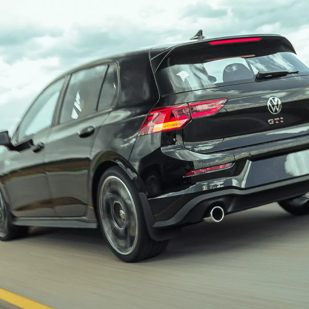 Rear view of the black 2026 Volkswagen Golf GTI on the road.