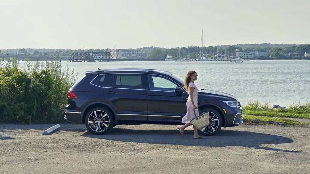 Vue latérale du Volkswagen Tiguan 2024 au bord d'un fleuve.