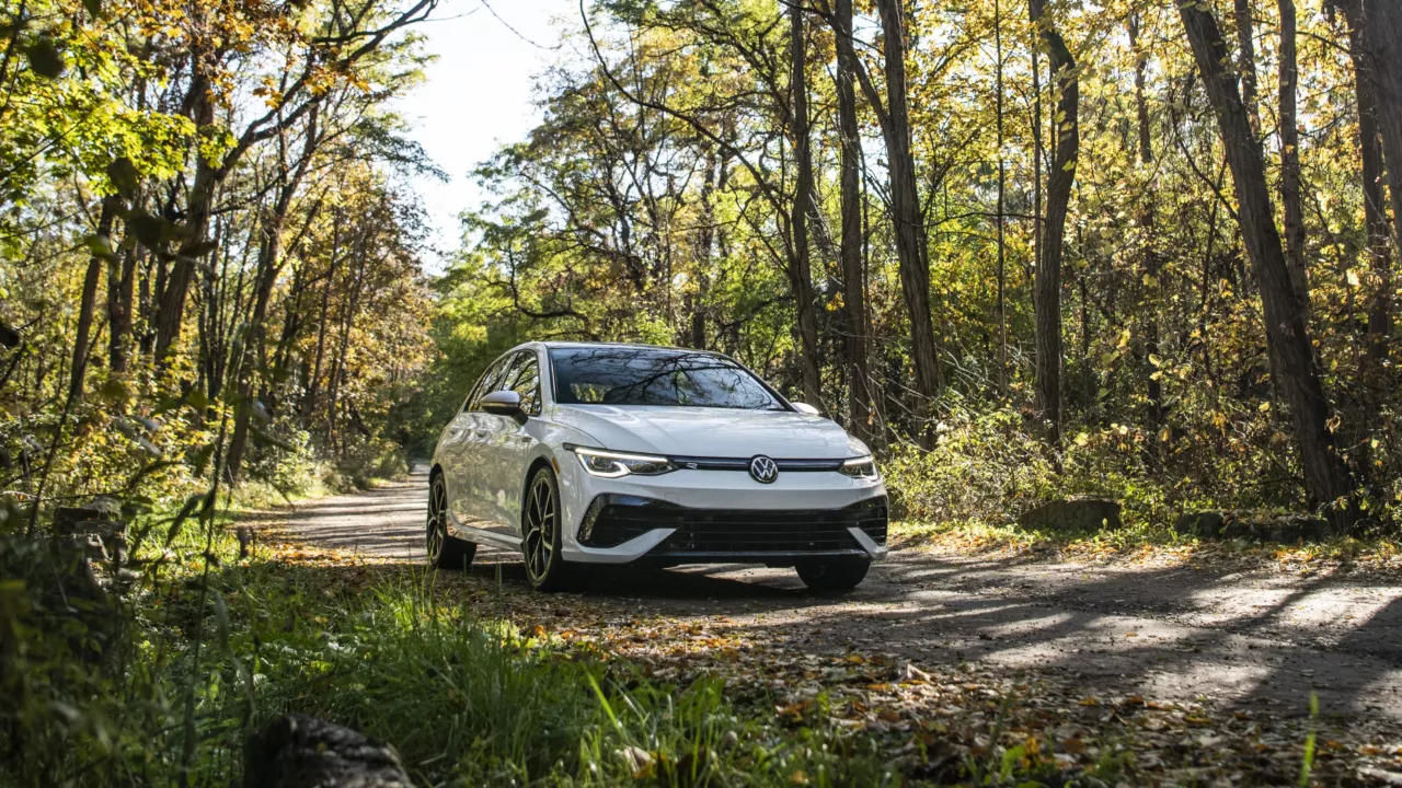 Front 3/4 view of 2024 VW Golf R parked in a forest.