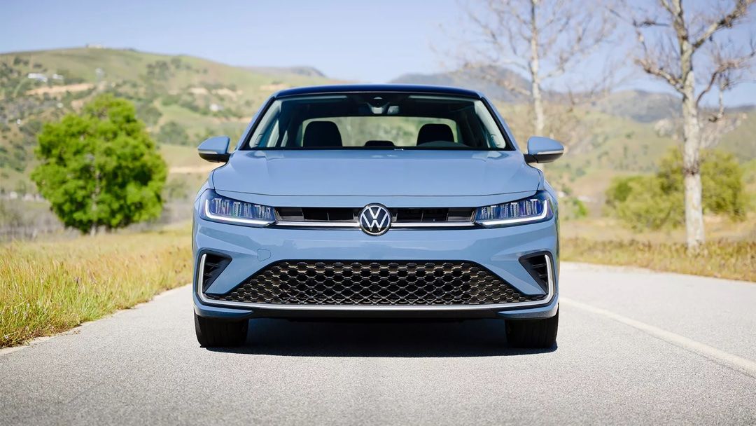 Front view of 2025 Volkswagen Jetta driving on a road.