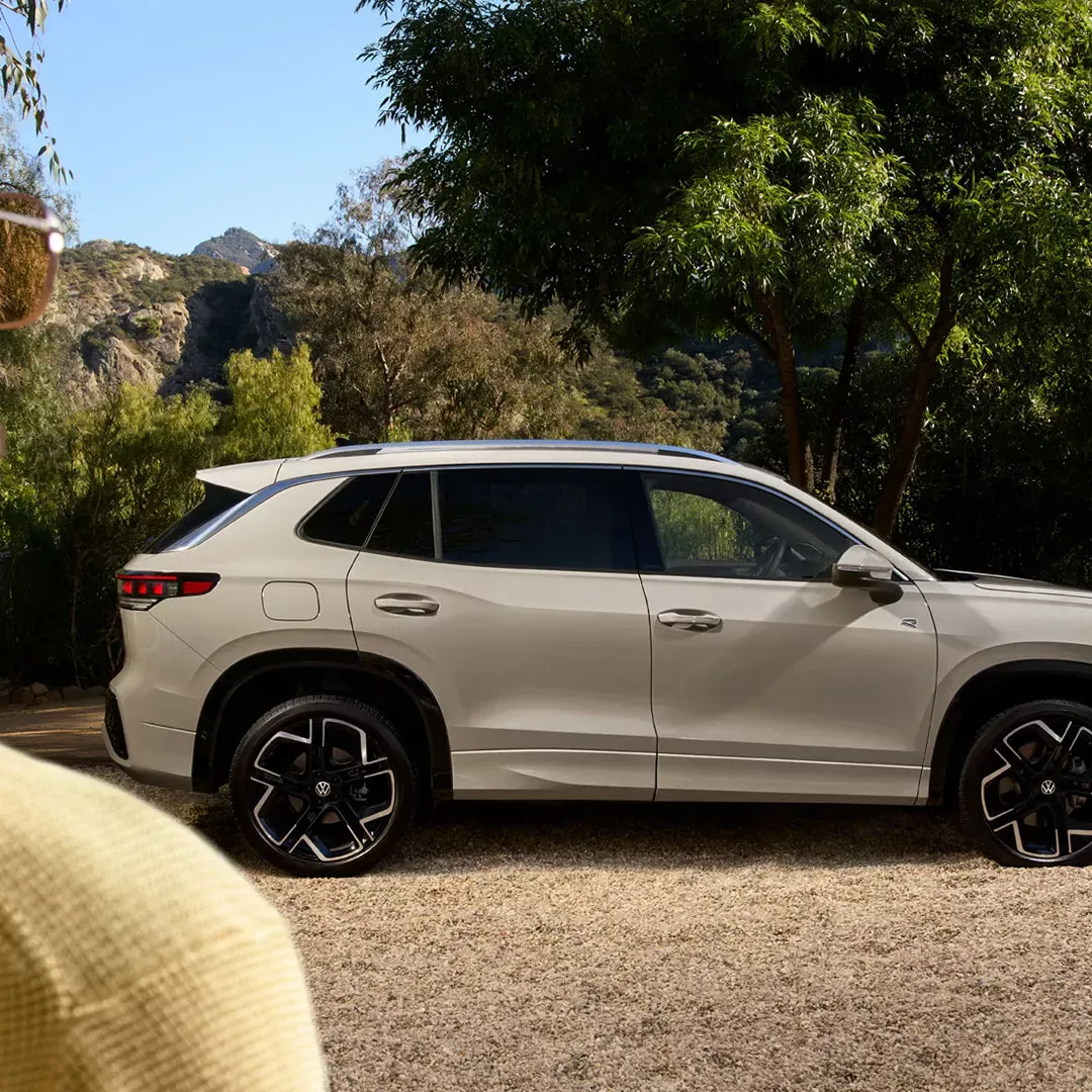 White Volkswagen Tiguan Highline seen in profile in a green setting.