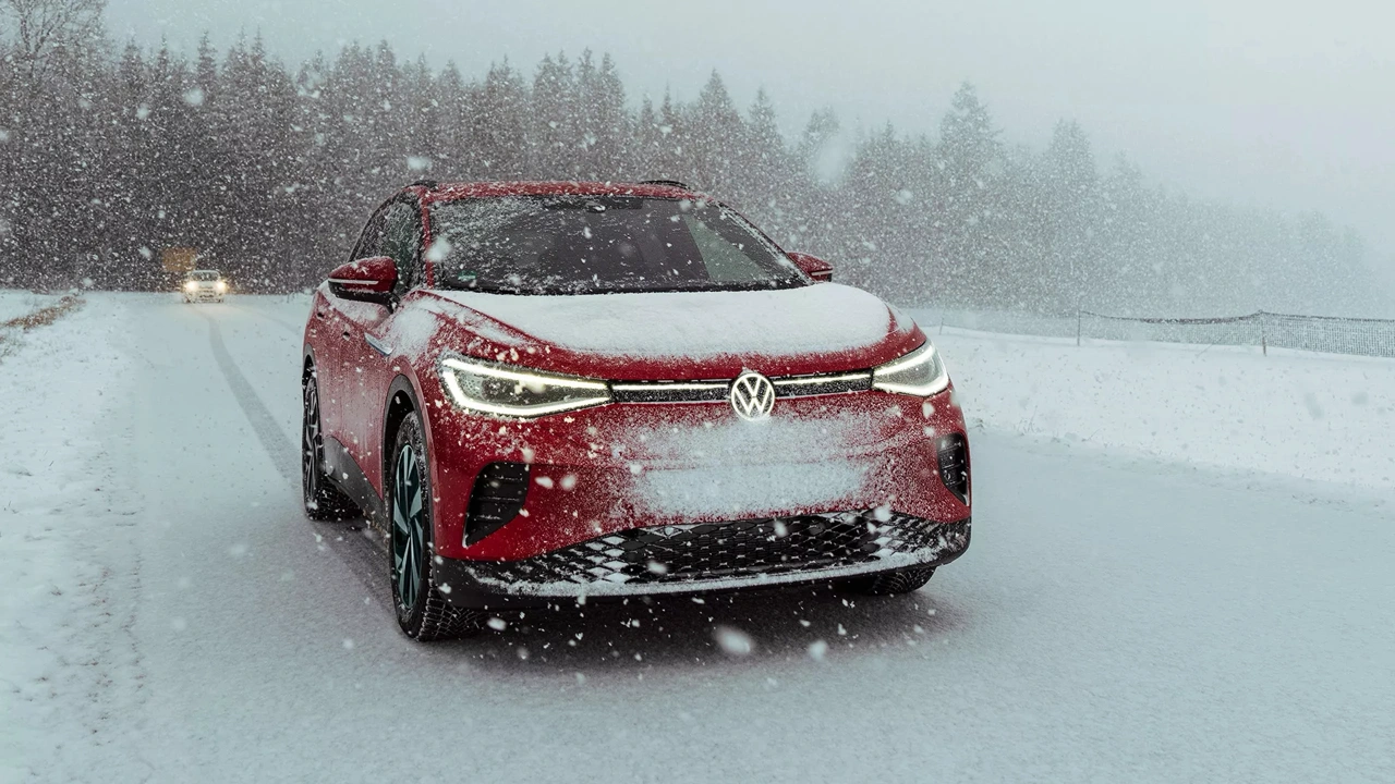 Volkswagen ID.4 2024 rouge sur route enneig&eacute;e dans le comparatif ID.4 2025 vs 2024.