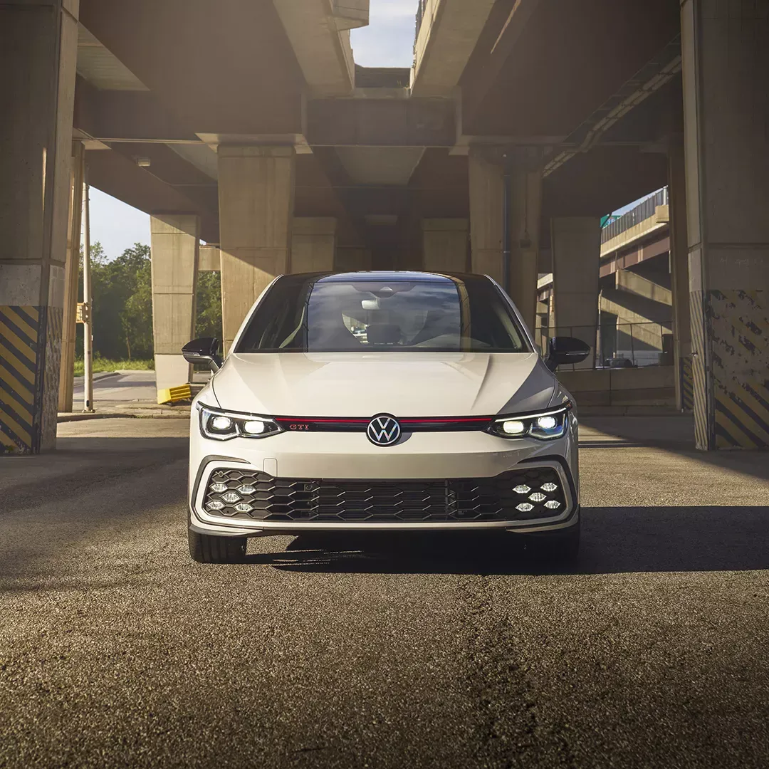 A white 2024 Volkswagen Golf GTI, viewed from the front&mdash;a sporty hatchback available at Arbour Volkswagen.