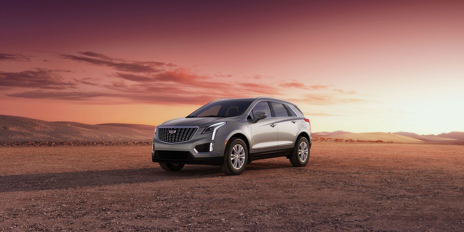 Vue 3/4 avant du Cadillac XT5 2023 garé sur une terre déserte.