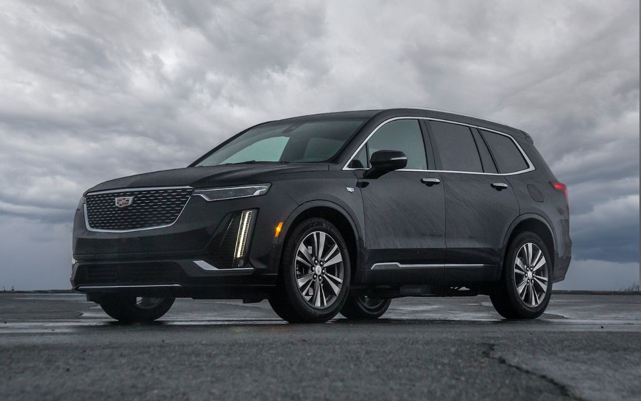 vue latérale avant d'une Cadillac XT6 2024 sur un tarmac un jour pluvieux