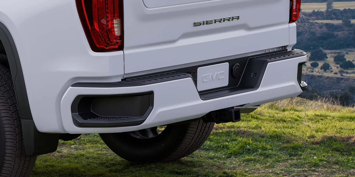 Détail de l’arrière du GMC Sierra 1500 2026 blanc, avec pare-chocs et marchepied intégrés, montrant sa fonctionnalité utilitaire.