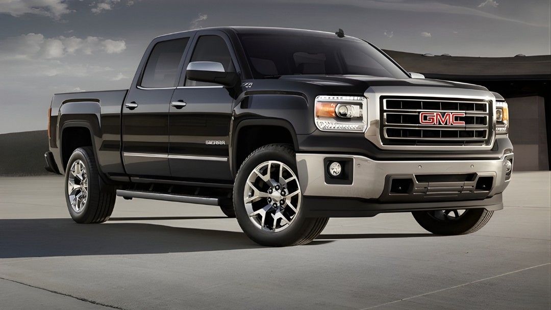 GMC Sierra 1500 Denali 2014 noir stationn&eacute; sur une surface b&eacute;tonn&eacute;e, illustrant la gamme haut de gamme des pickups GMC.