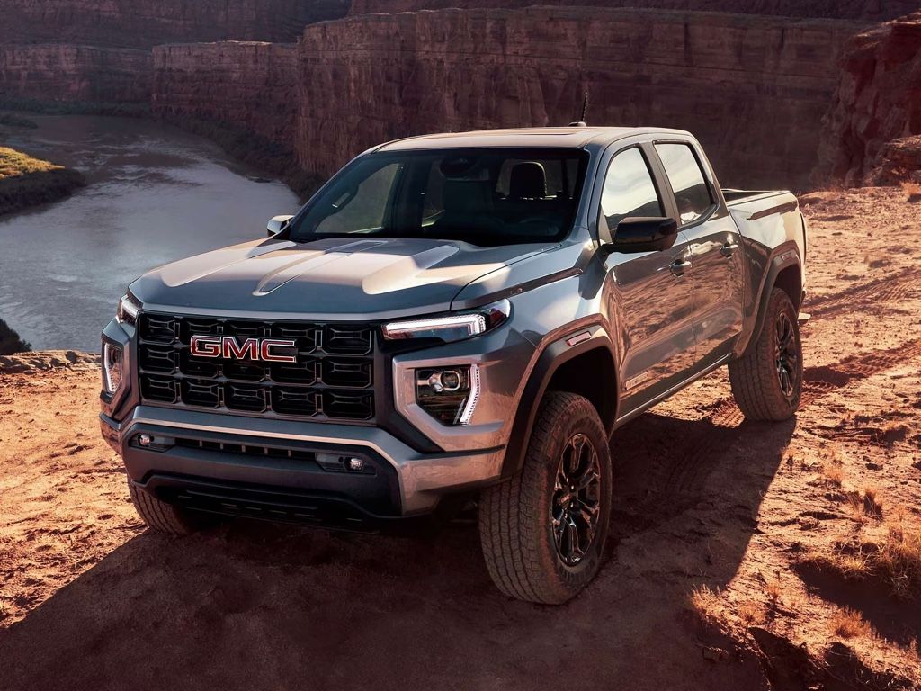 GMC Canyon 2025 gris surplombant un canyon, repr&eacute;sentant un parfait &eacute;quilibre entre style, puissance et maniabilit&eacute;.