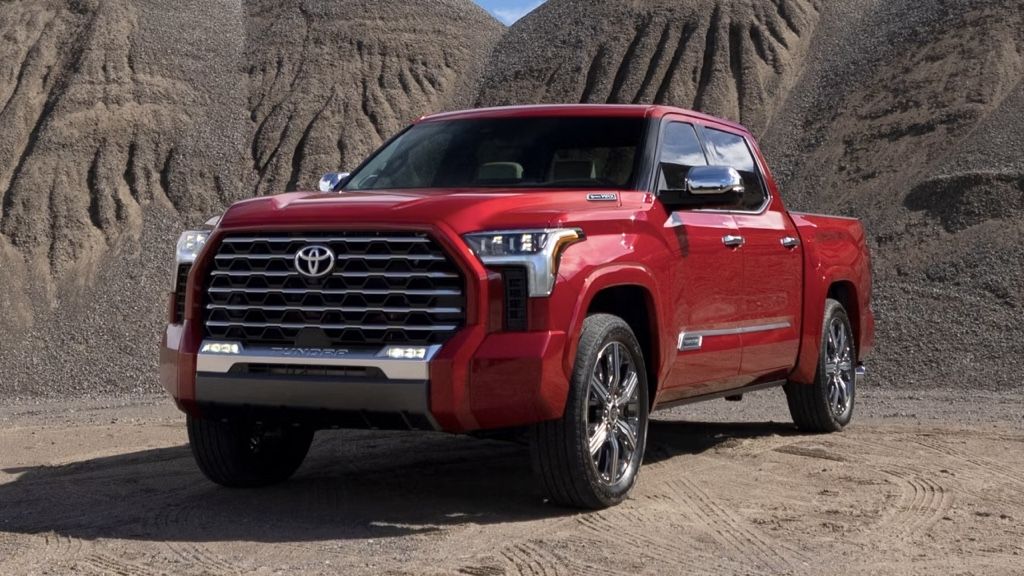 Toyota Tundra 2025 rouge stationn&eacute; devant un paysage d&eacute;sertique, soulignant son design audacieux et ses performances puissantes.