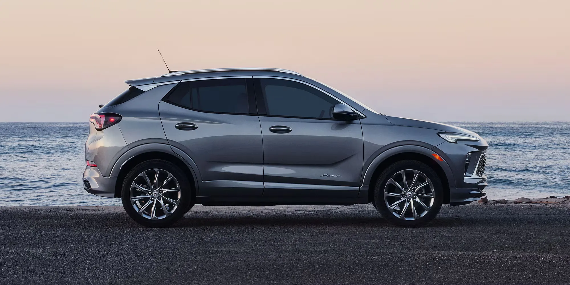 Vue de profil du Buick Encore GX Avenir 2026 au bord de la mer.