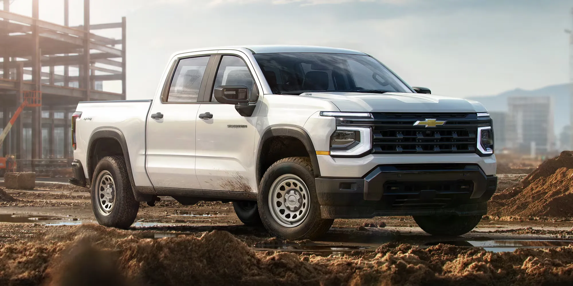 Chevrolet Silverado 1500 2027 blanc sur un terrain boueux.