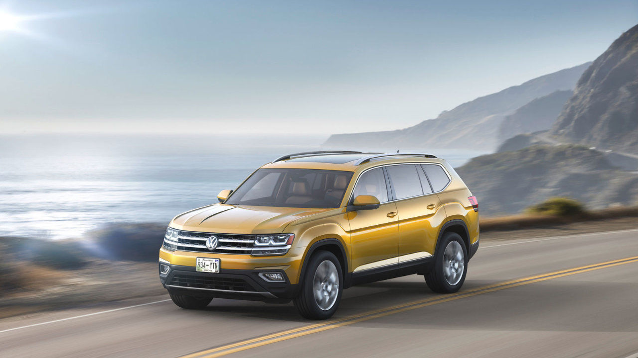 Front 3/4 view of the 2023 Volkswagen Atlas SUV driving on a road.
