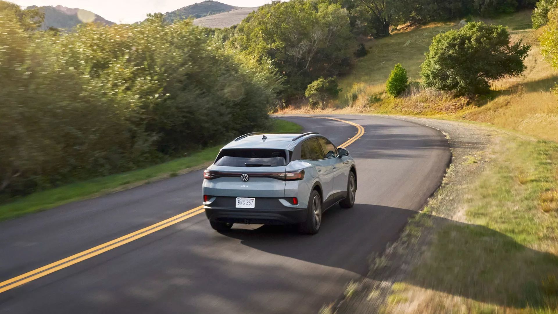 Vue arrière Du Volkswagen ID.4 2024 qui roule sur une route de campagne.