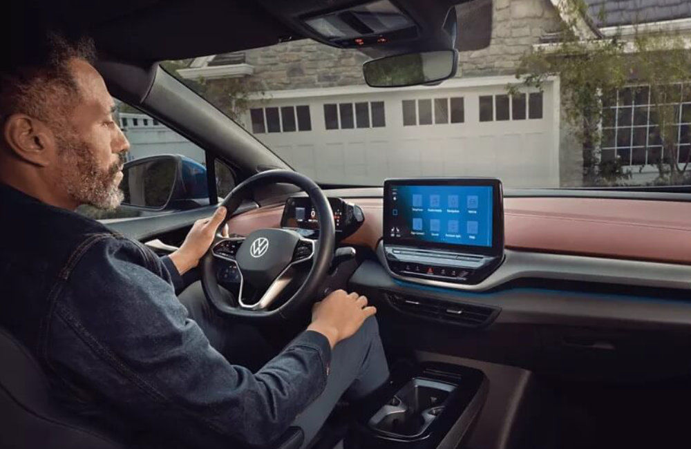 vue d'un conducteur qui interagi avec le tableau de bord de sa VW ID.4 2023