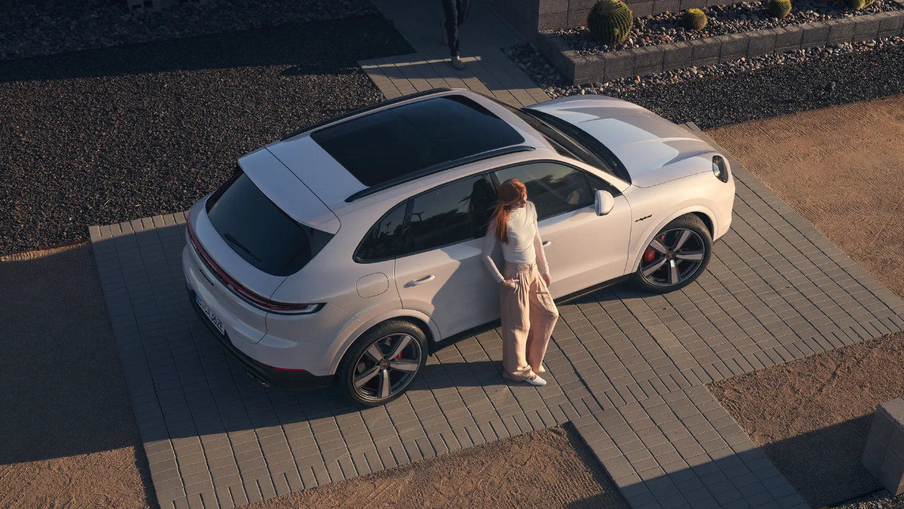 overhead view of a young woman leaning against a 2024 Porsche Macan