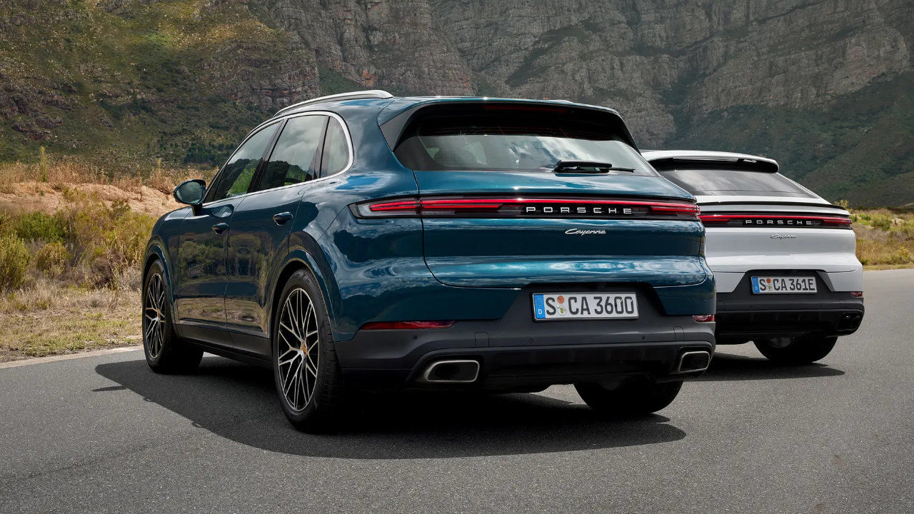 rear side view of a duo of 2024 Porsche Cayenne on a road near a steep cliff