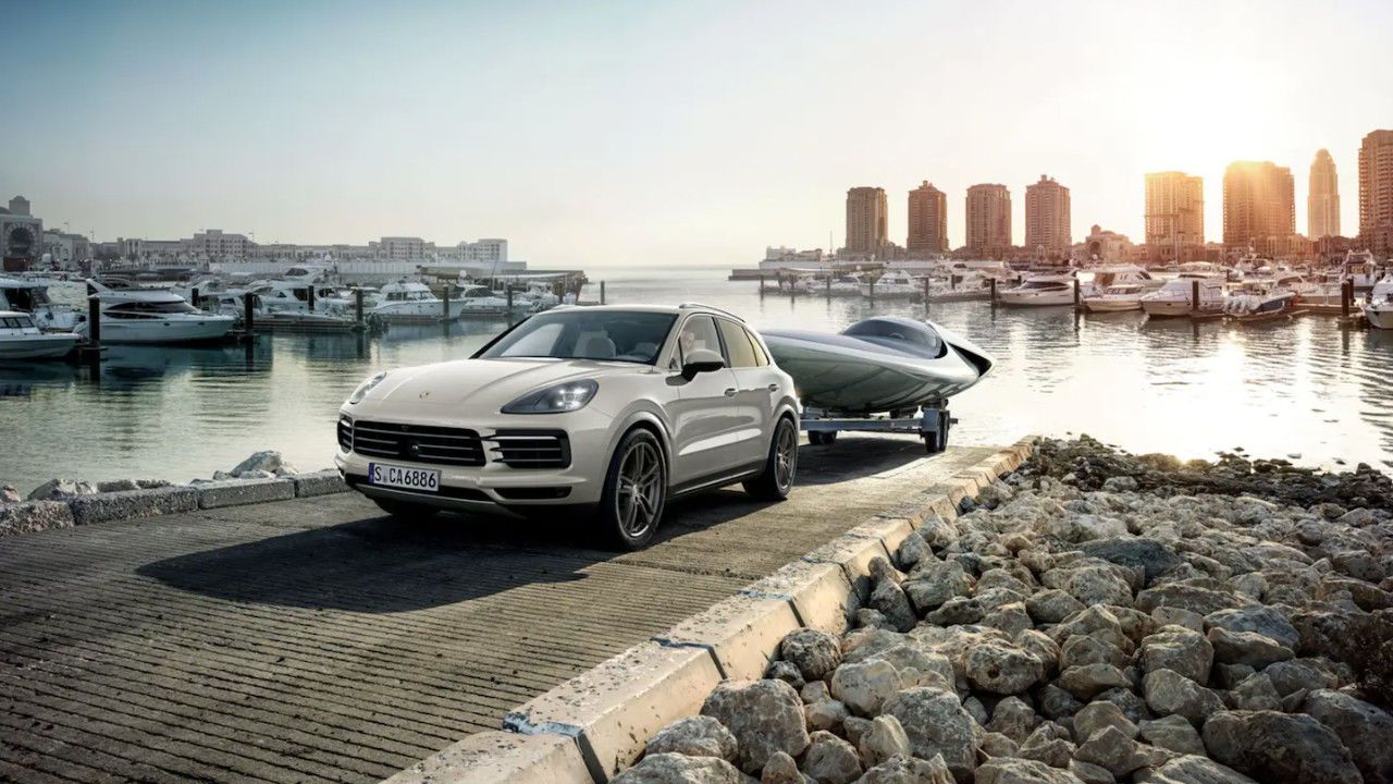 front side view of a 2023 Porsche Cayenne towing a boat out of the water