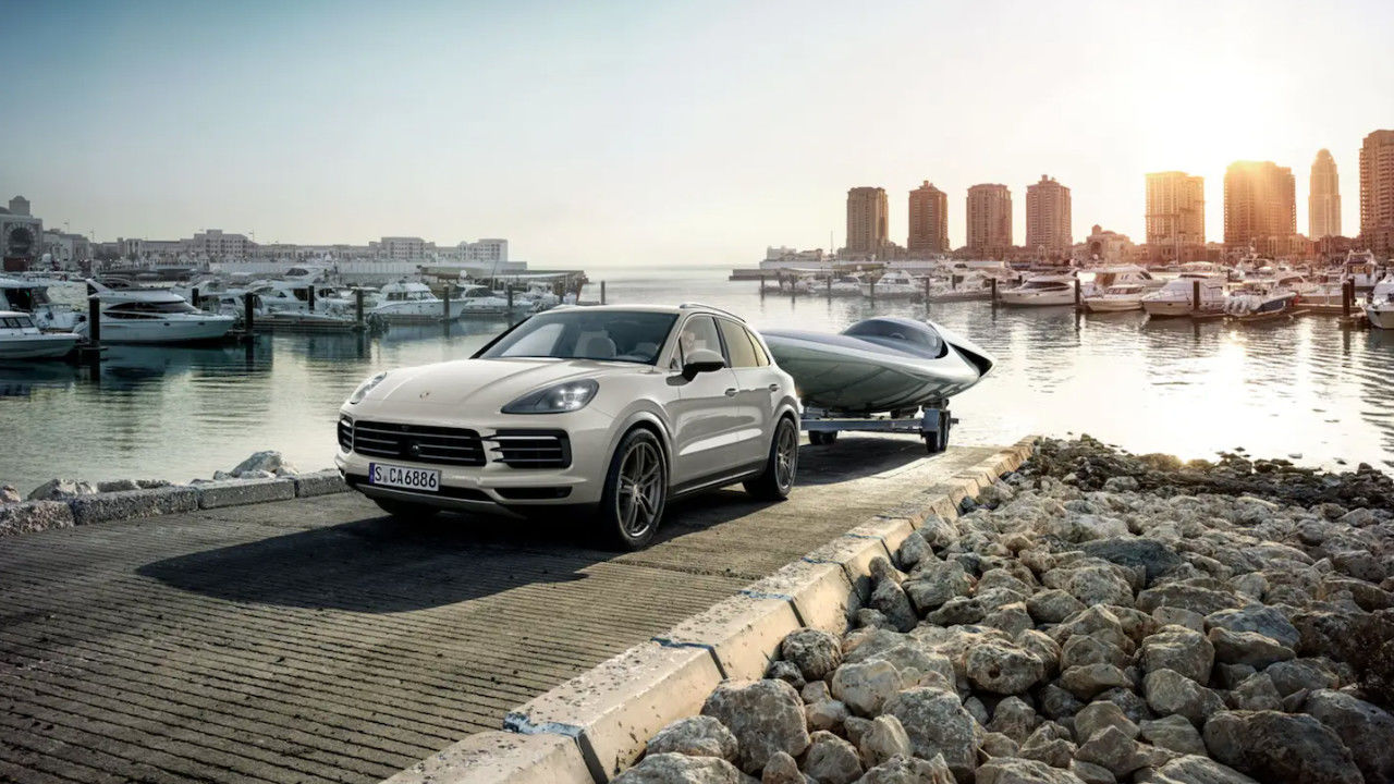 vue latérale avant d'une Porsche Cayenne 2023 remorquant un bateau hors de l'eau