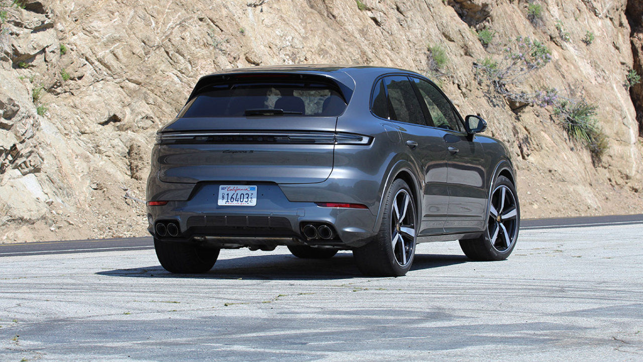 rear side view of a 2024 Porsche Cayenne next to a rocky cliff