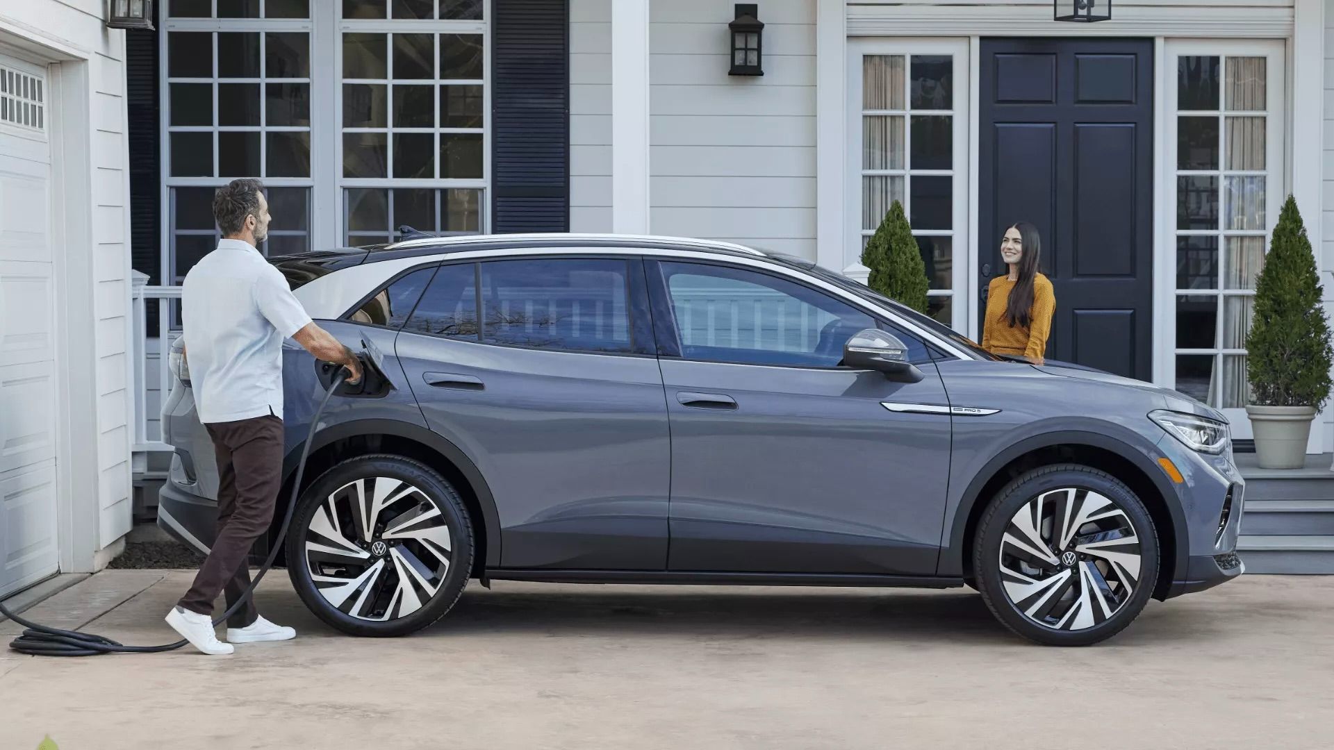 Un homme qui qui branche sa Volkswagen ID.4 à sa résidence.