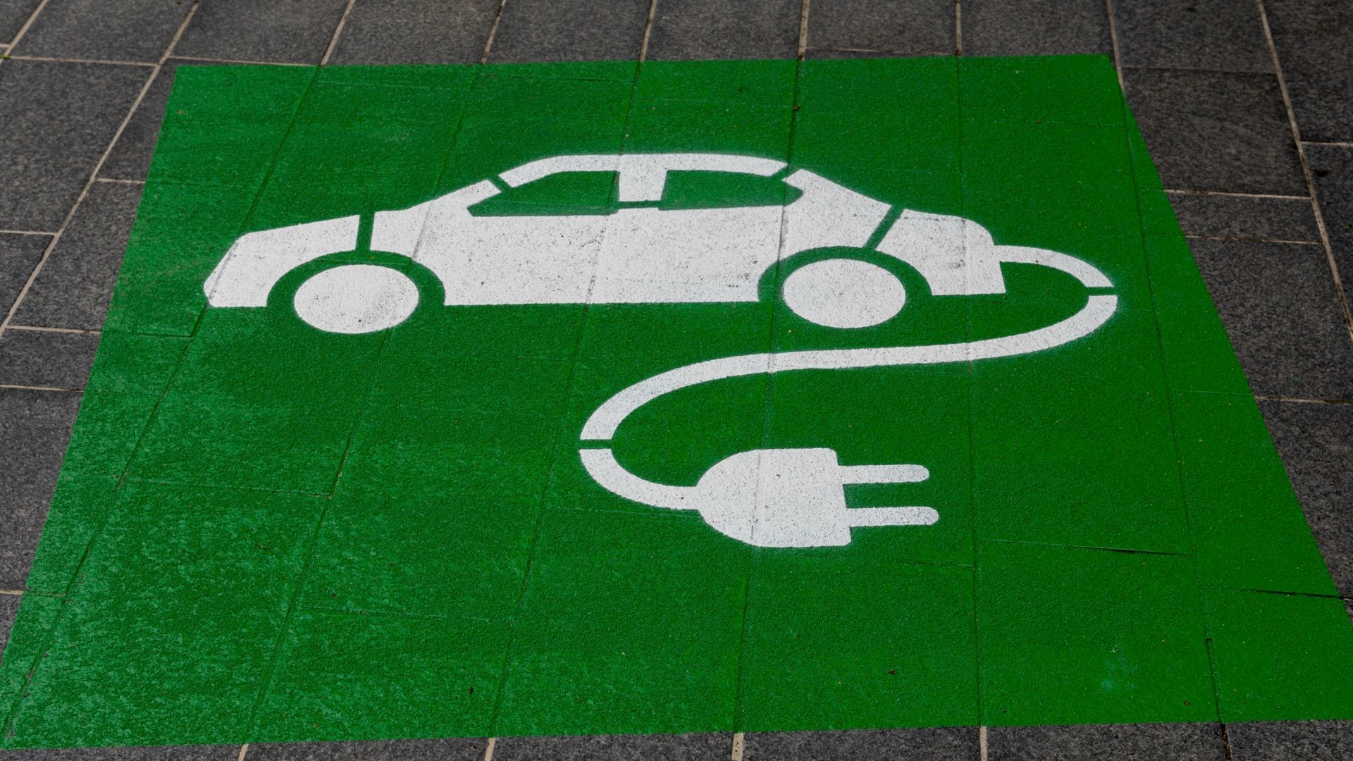 Place de parking avec un dessin de voiture électrique.