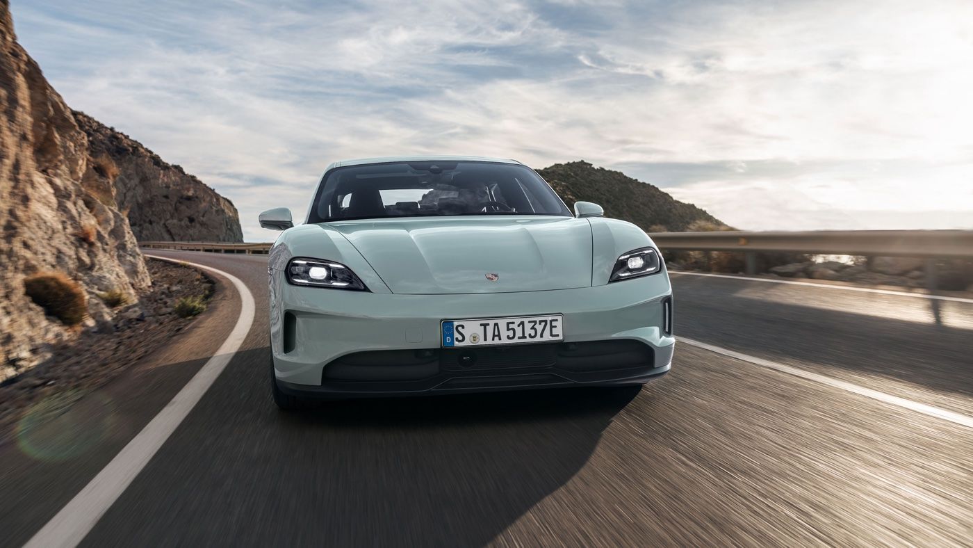 Front view of the 2025 Porsche Taycan electric driving on a road.