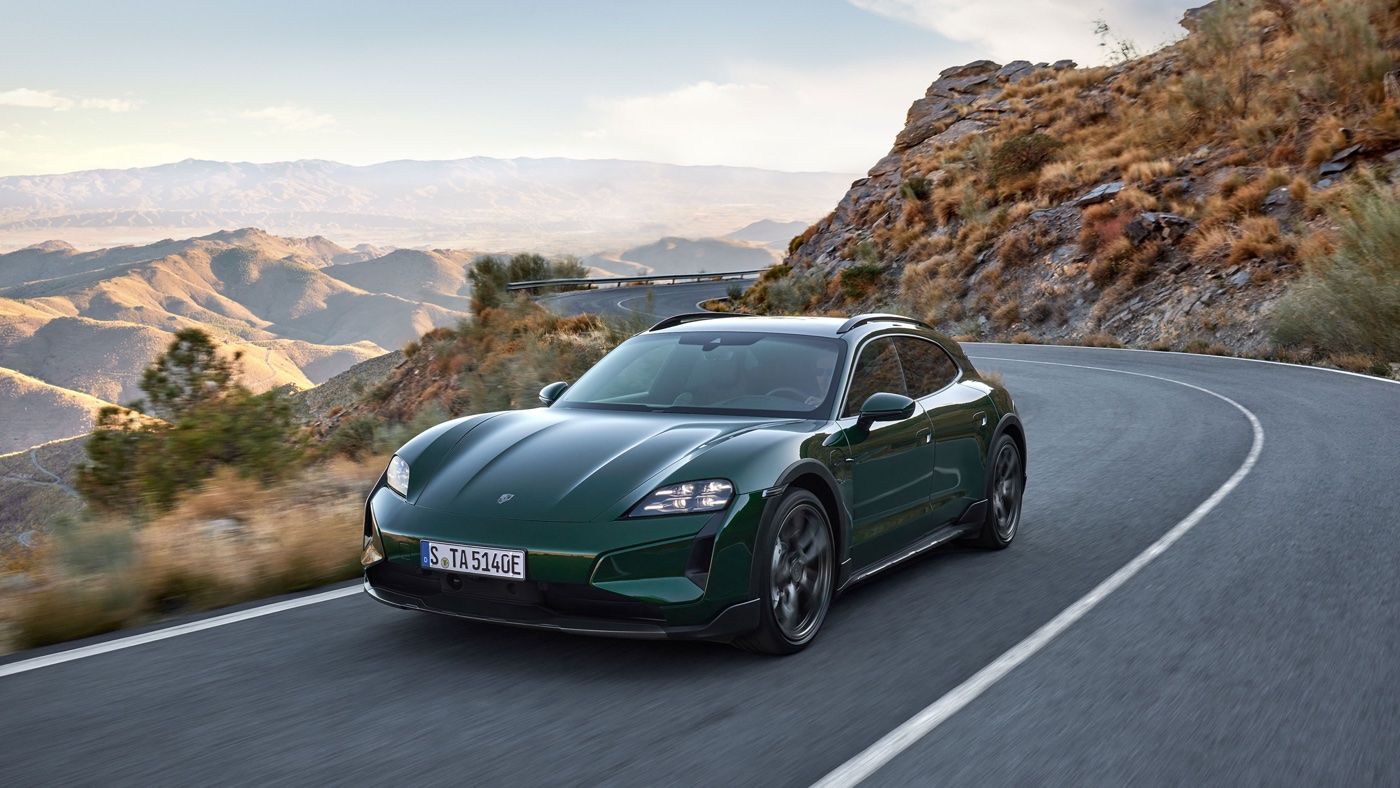 Front 3/4 view of 2025 Porsche Taycan Cross Turismo driving on a road.