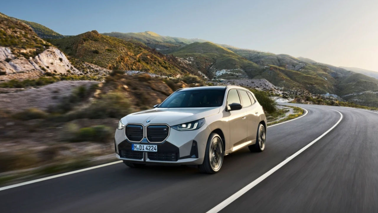 vue latérale avant d'une BMW X3 2025 sur une route de montagne