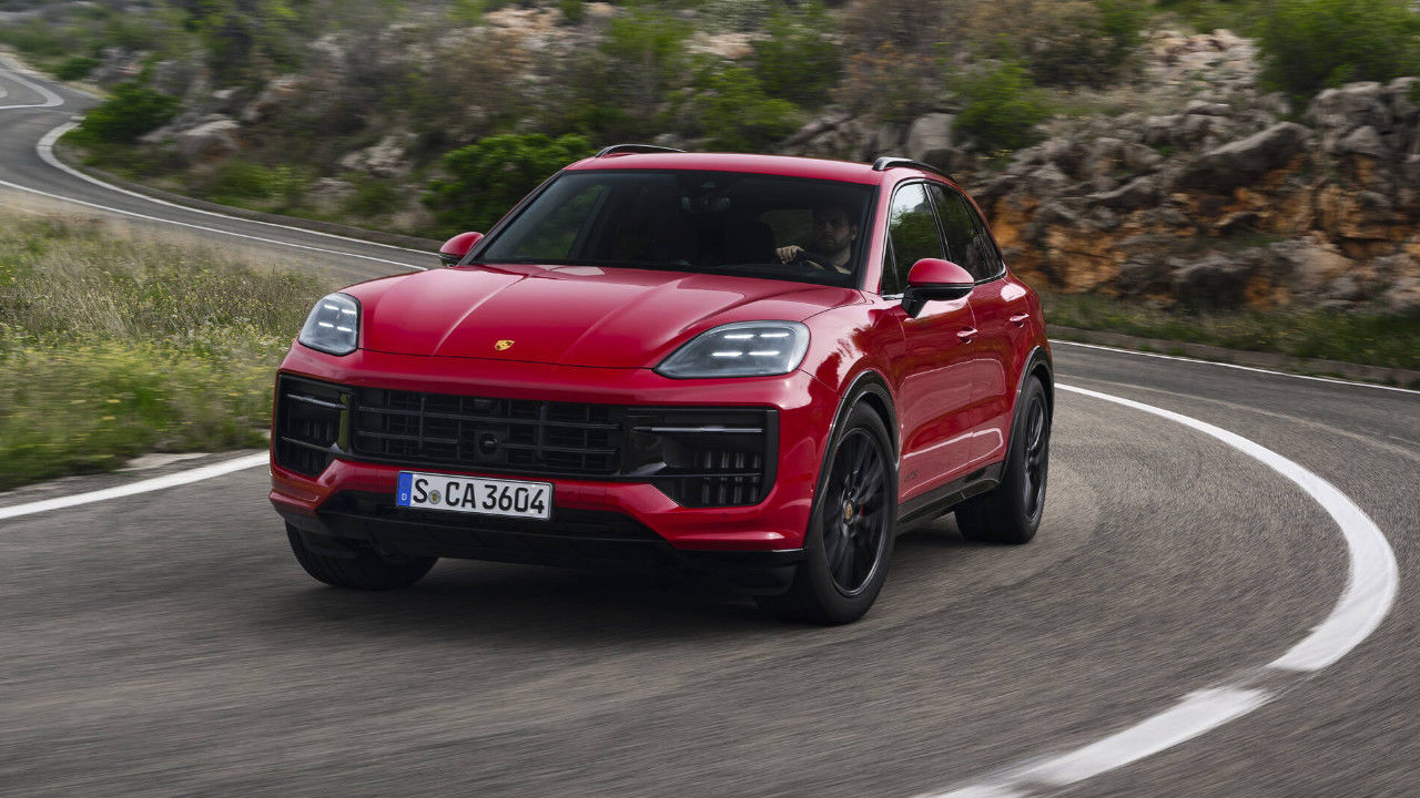 vue latérale avant d'une Porsche Cayenne 2025 sur une route de campagne