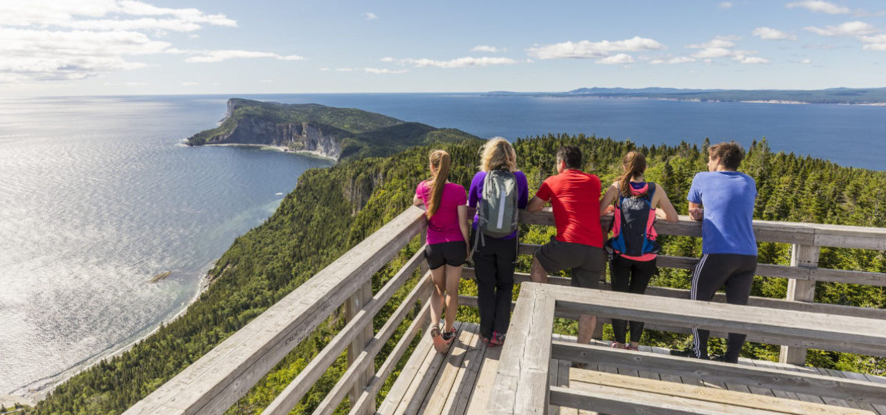 family looking at the horizon on lookout point at Forillon National Park