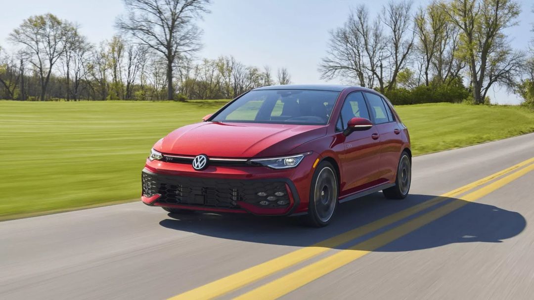 Volkswagen Golf GTI 2026 rouge en mouvement sur route de campagne, montrant son design sportif et sa performance récompensée par MotorTrend.