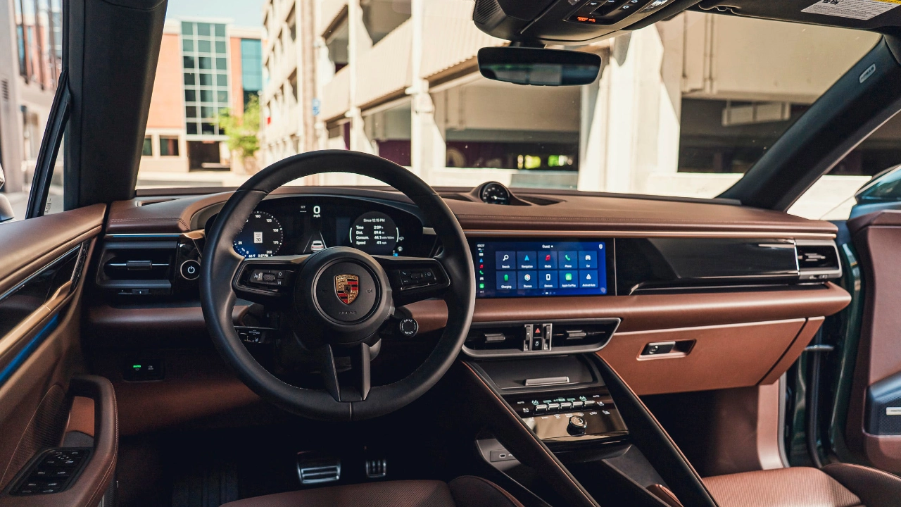 Vue de l'habitacle avant du Porsche Macan montrant le cockpit numérique et les écrans multimédias