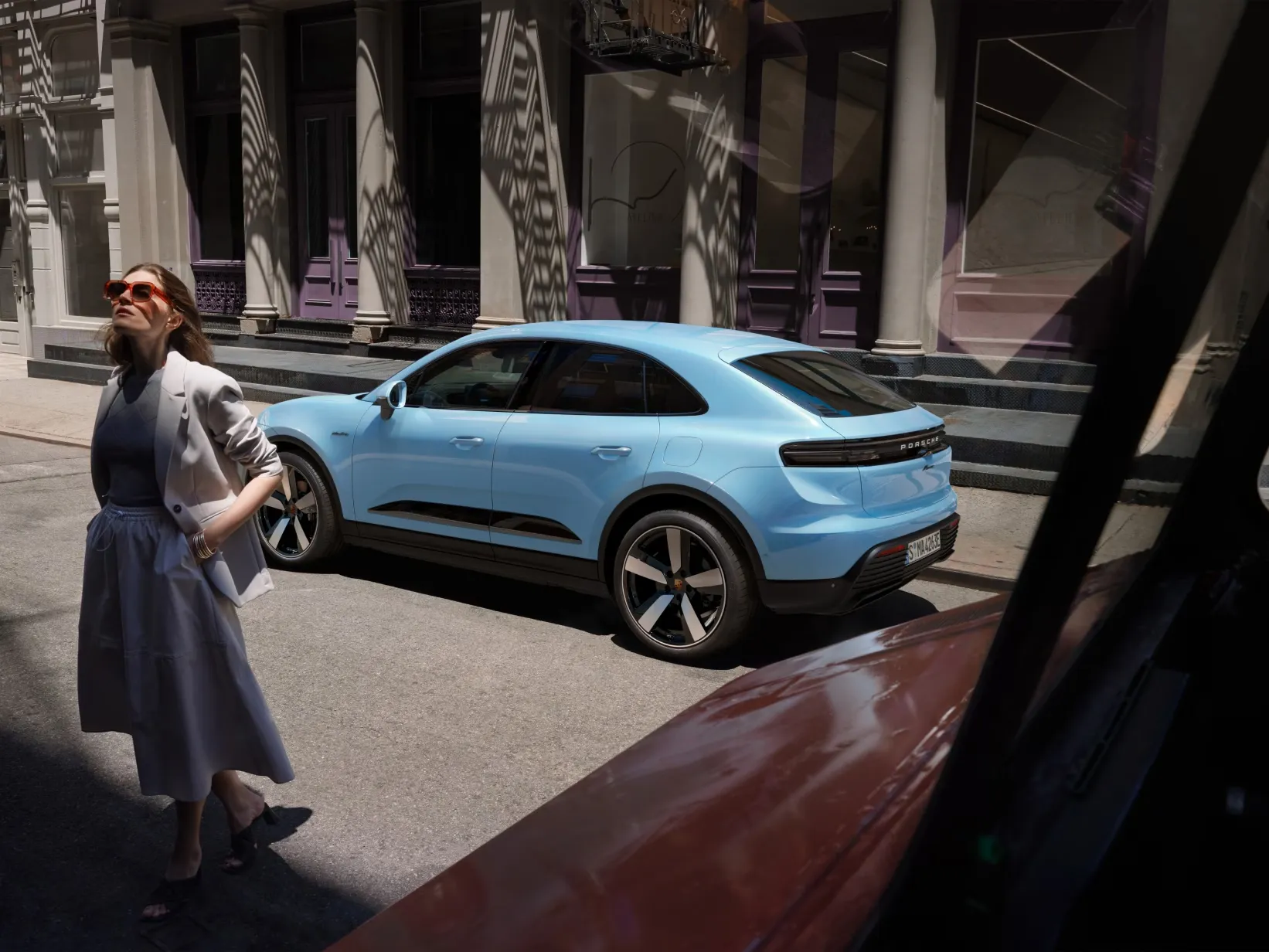 Blue 2026 electric Porsche Macan parked in an urban setting to conclude the article on pricing and technical specifications.