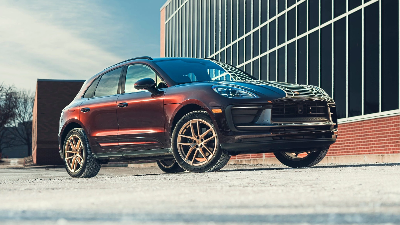 Side profile of a Porsche Macan SUV driving on a road