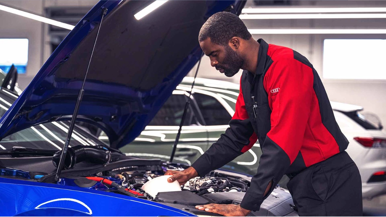 Certified Audi technician inspecting the engine bay during a multi-point check