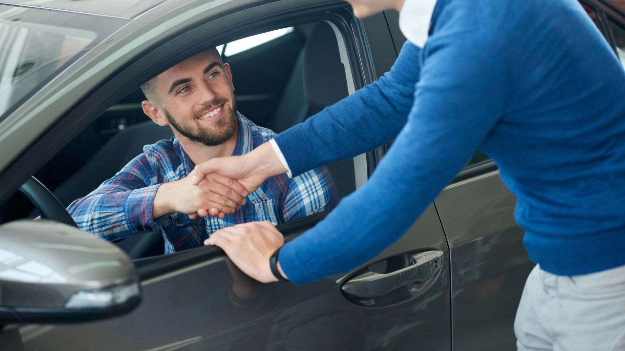 A dealership representative discussing trade-in options with a client across a desk