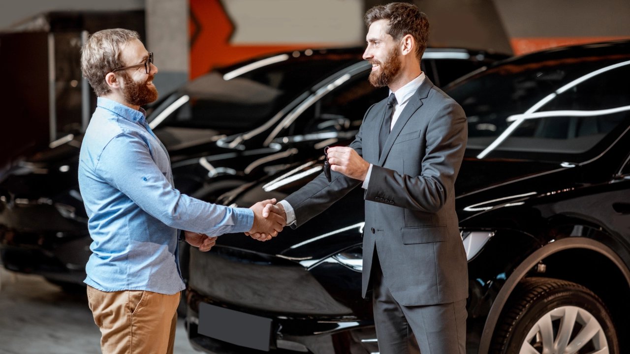 Close-up of a person signing a formal vehicle purchase and sale agreement