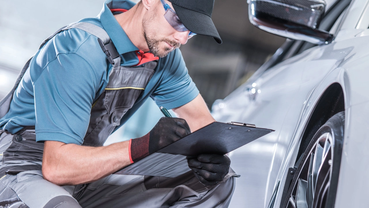 Automotive specialist inspecting the body and paint of a vehicle for an appraisal