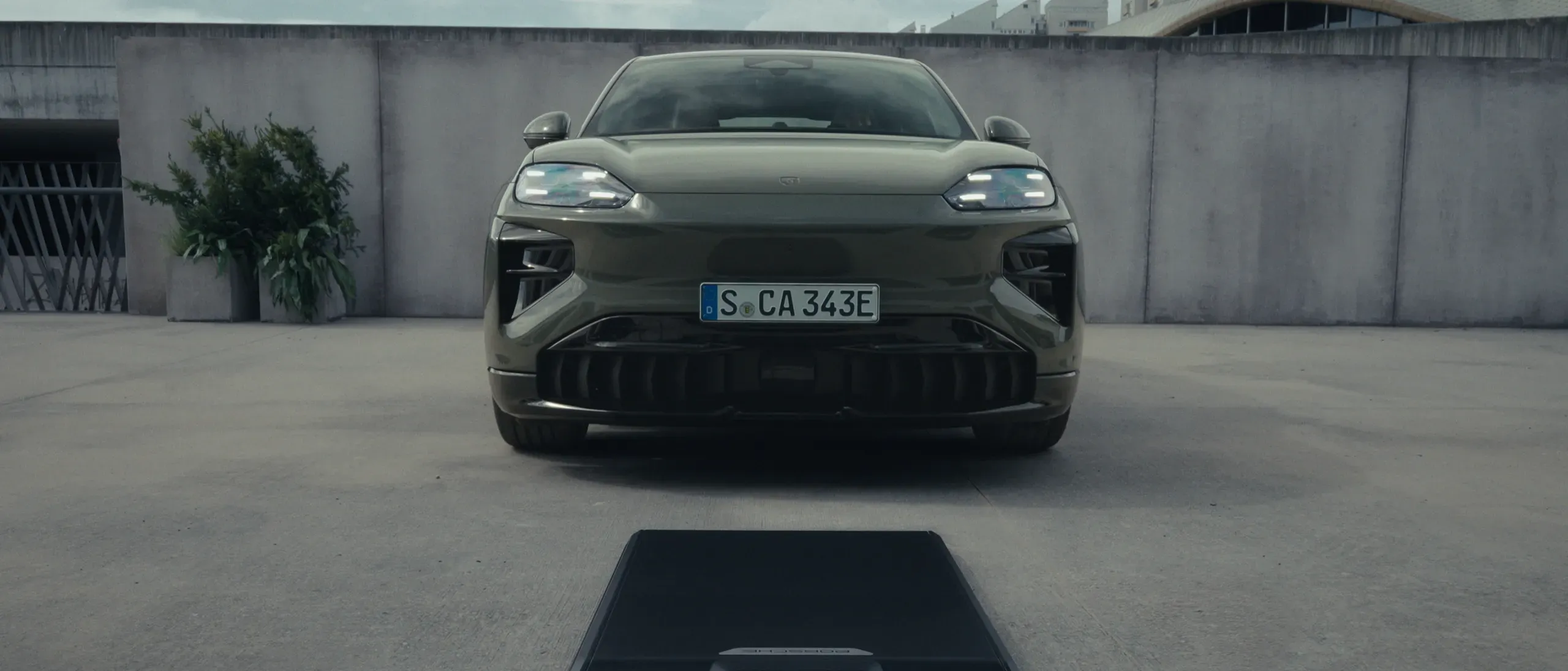Front view of the 2027 Porsche Cayenne electric coupe, showing its headlights and front bumper.