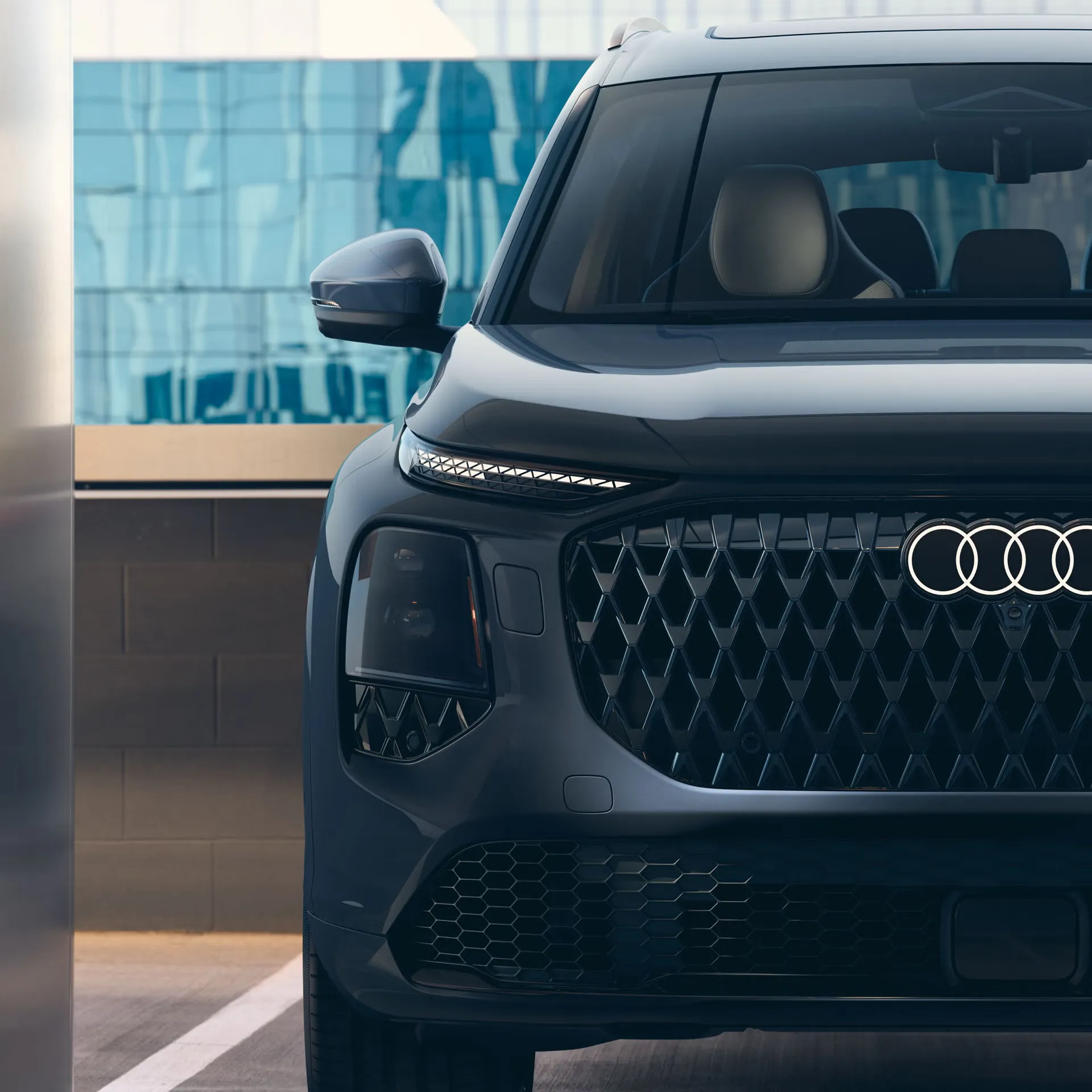 Close-up of the front grille and headlights of a blue 2027 Audi Q7.
