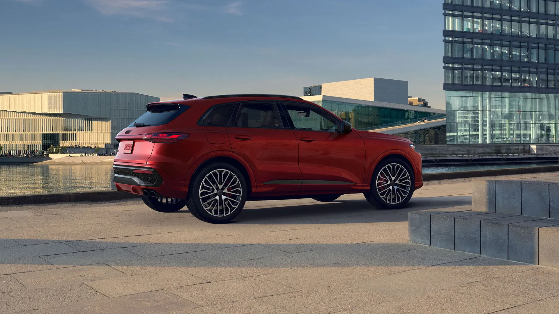 Audi SQ5 2026 rouge vu de trois quarts arri&egrave;re en milieu urbain, dans la section sur le budget d&rsquo;un VUS.