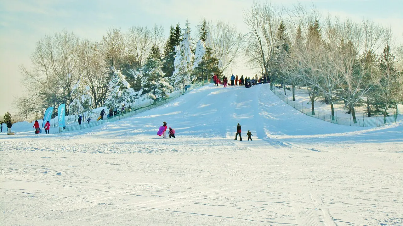 Butte de glissade enneig&eacute;e au Centre de la Nature de Laval pour une sortie hivernale en famille.