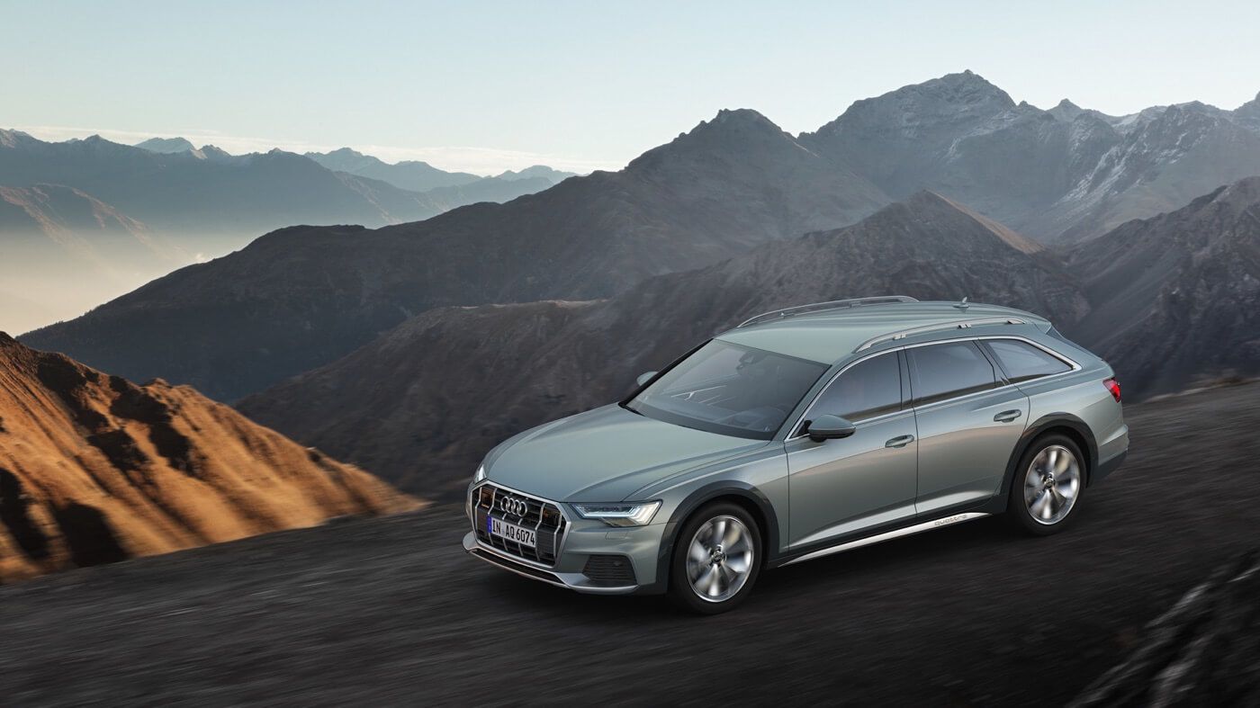 An Audi A6 allroad SUV driving on a road at the edge of volcanoes