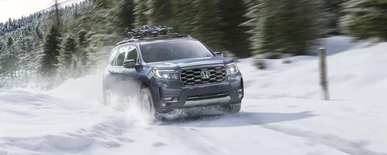 front side view of a 2023 Honda Passport on a snowy forest road