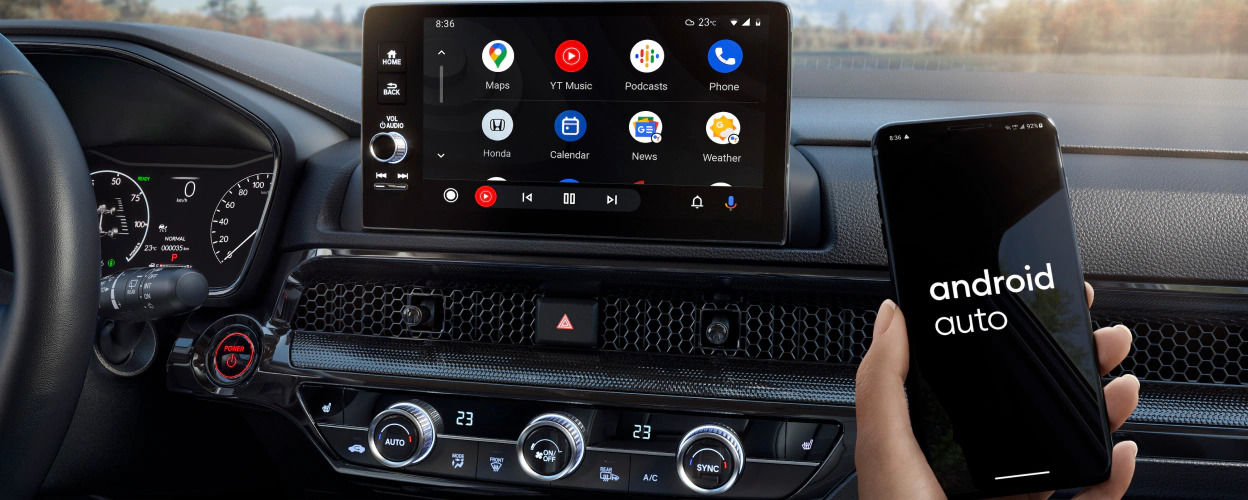 Une personne tient un mobile avec l'application Android Auto, à bord du Honda CR-V hybride 2023.