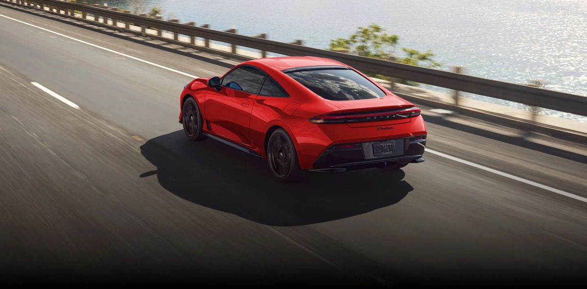 Honda Prelude 2026 rouge vue arrière sur route côtière ensoleillée, illustrant le retour du coupé sportif emblématique de Honda.