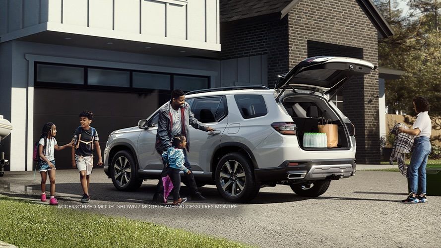 A family preparing for a trip aboard the Honda Pilot 2025.