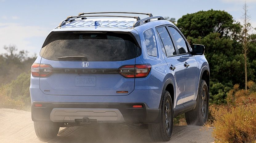 Rear view of the Honda pilot TrailSport 2025 on a dirt road.