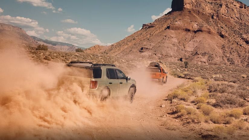 Deux Honda Passport sur un chemin de terre qui roule entre les montagnes.